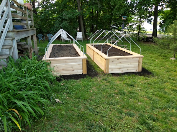 two raised garden beds with row cover ready for plants